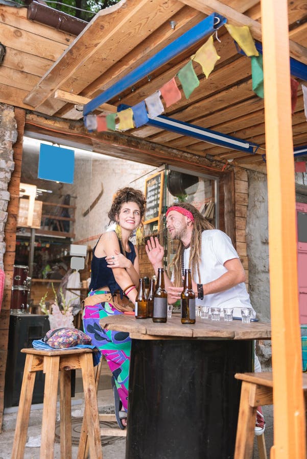 Due giovani hippy moderni che si siedono nella barra piacevole dell'alcool fotografia stock Due giovani hippy moderni che si siedono nella barra piacevole dell'alcool fotografia stock