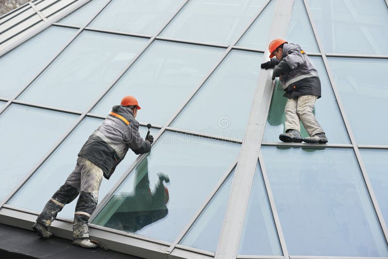 Due lavoratori che installano finestra esterna fotografia stock libera da diritti Due lavoratori che installano finestra esterna fotografia stock libera da diritti