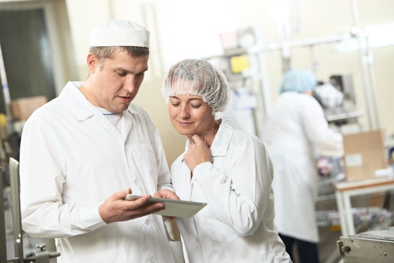 Due lavoratori di industria della farmacia con il pc della compressa fotografie stock libere da diritti Due lavoratori di industria della farmacia con il pc della compressa fotografie stock libere da diritti