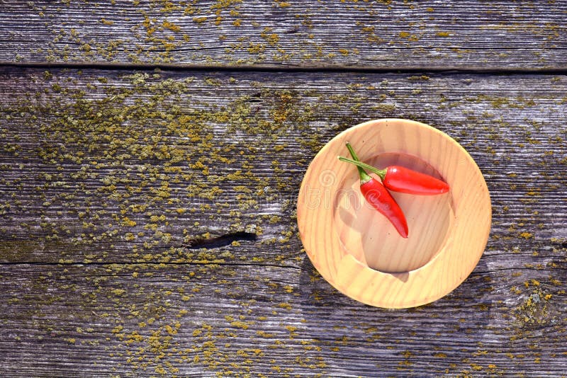 Due peperoncini roventi in piatto di legno su vecchio fondo fotografie stock libere da diritti Due peperoncini roventi in piatto di legno su vecchio fondo fotografie stock libere da diritti