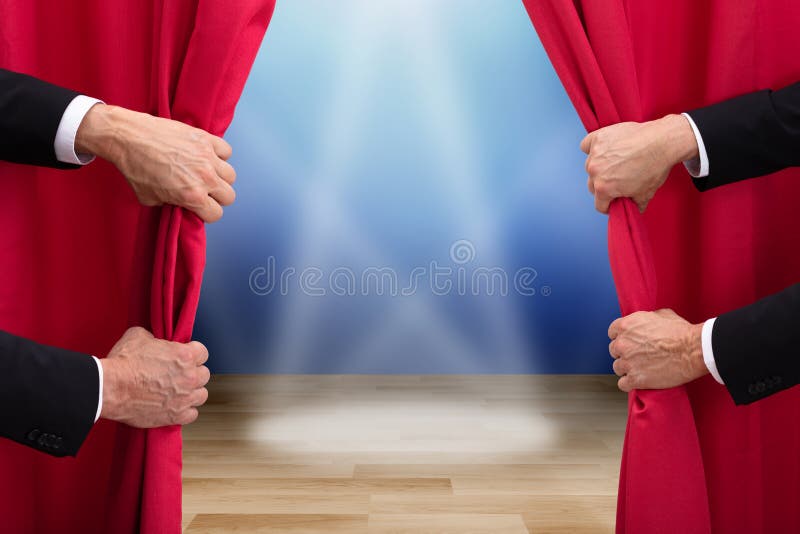 Due persone che aprono una cortina rossa