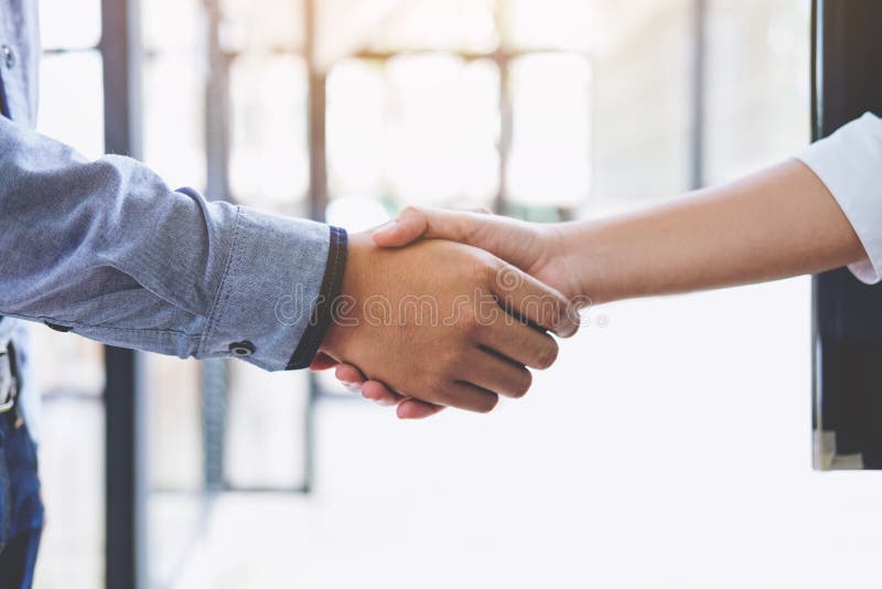 Due persone di affari che stringono le mani nel corso di una riunione nell'ufficio, fotografie stock Due persone di affari che stringono le mani nel corso di una riunione nell'ufficio, fotografie stock