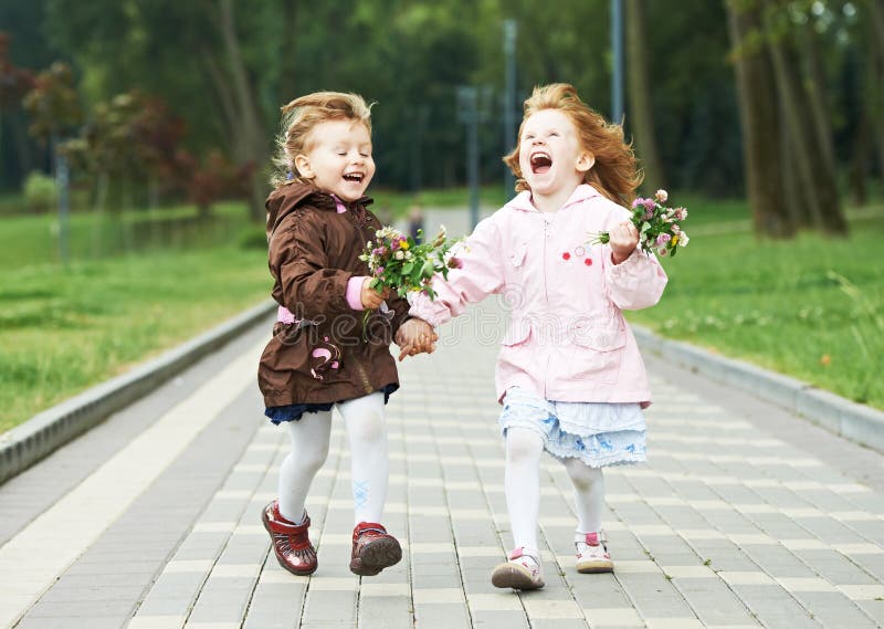Due piccole ragazze di risata dei bambini all'aperto