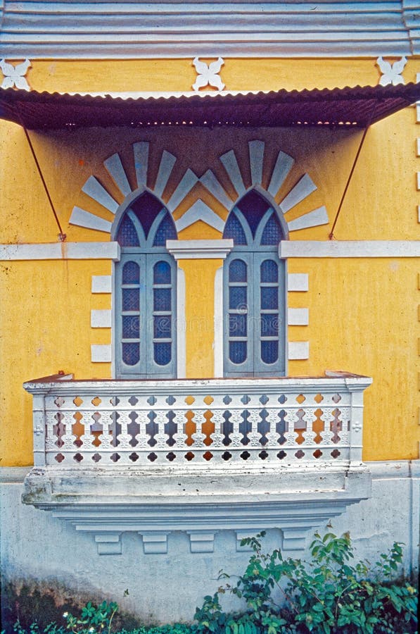 Due porte al balcone e al capanno del tempo della villa dipinta di giallo e bianco immagini stock