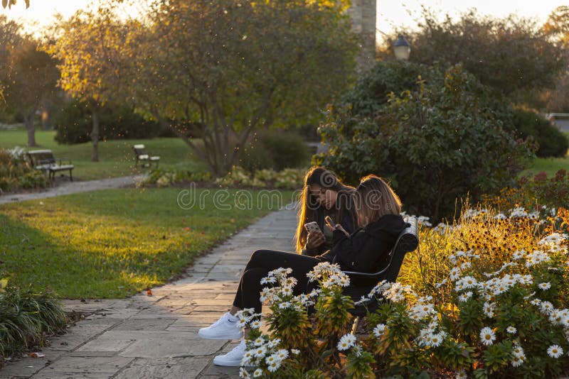 Due ragazze adolescenti sedute su una panchina a Baker Park al tramonto fotografie stock libere da diritti