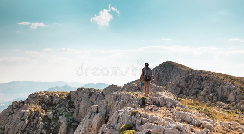 Due ragazze con zaini camminano lungo il sentiero di montagna fotografia stock