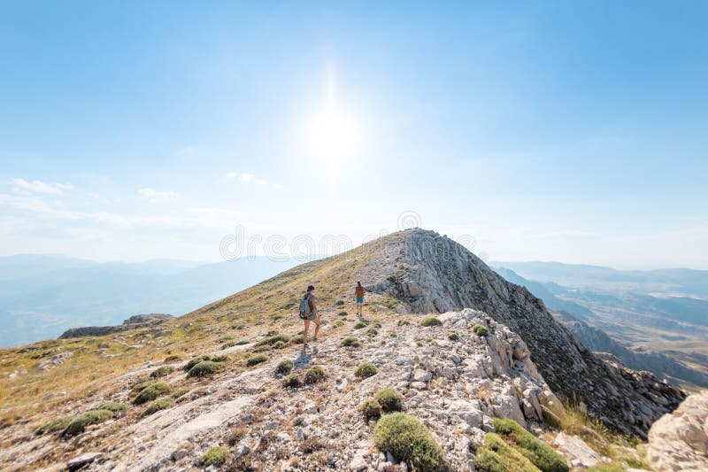 Due ragazze con zaini camminano lungo il sentiero di montagna fotografia stock libera da diritti
