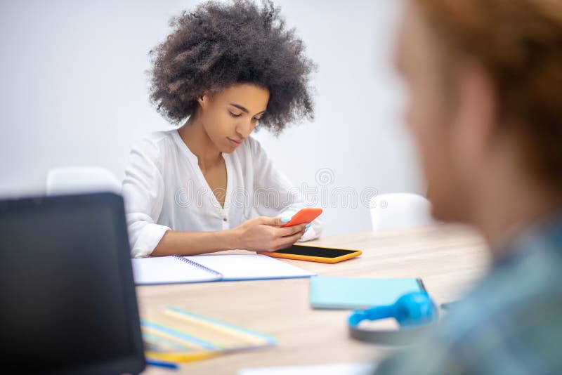 Due ragazze sedute al tavolo in ufficio immagini stock