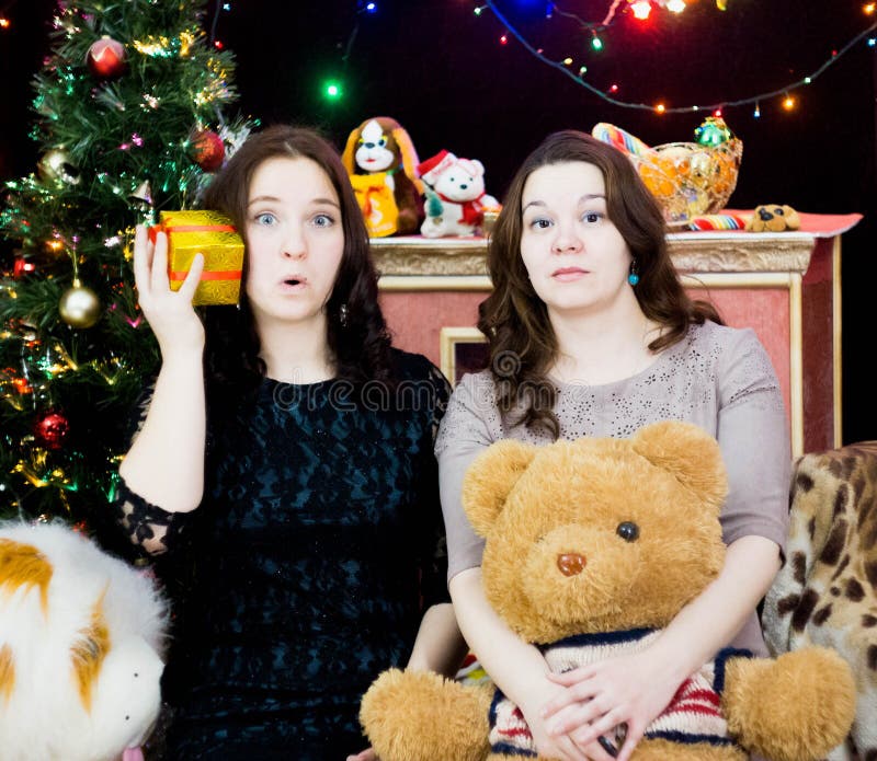 Due ragazze in una regolazione di Natale fotografia stock libera da diritti Due ragazze in una regolazione di Natale fotografia stock libera da diritti