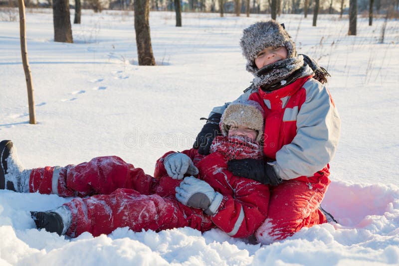 Due ragazzi che giocano al parco di inverno immagine stock libera da diritti Due ragazzi che giocano al parco di inverno immagine stock libera da diritti