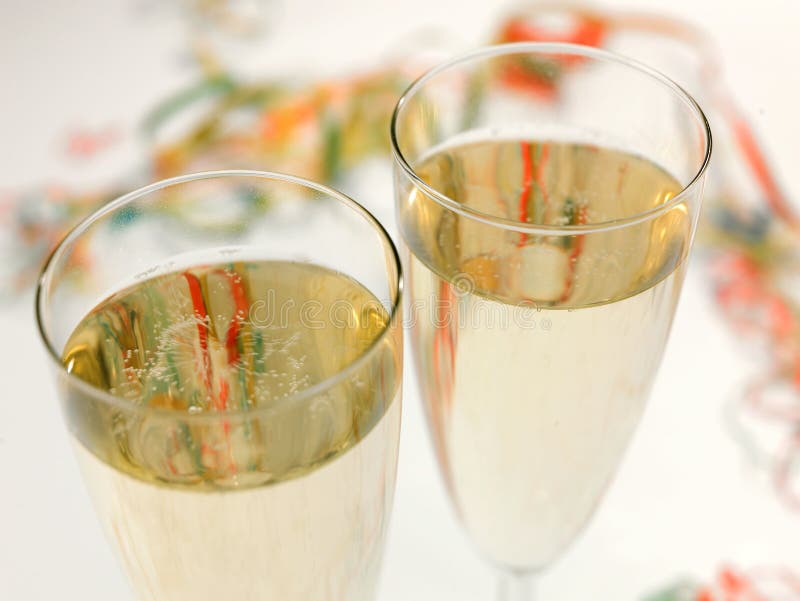 Two glasses of Champagne close up using differential focus, with streamers behind. Two glasses of Champagne close up using differential focus, with streamers behind
