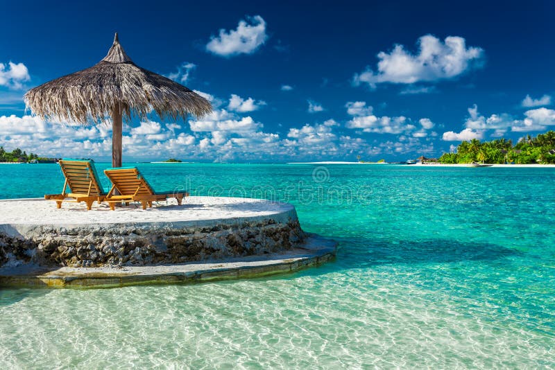Due sedie di spiaggia sotto l'ombrello con la vista di oceano in Maldive immagine stock libera da diritti