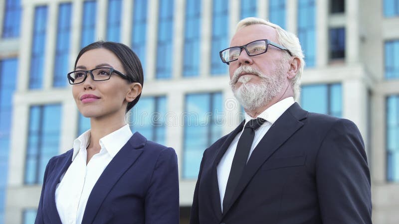 Due soci commerciali sicuri che stanno il centro dell'ufficio di aria aperta, esperienza fotografie stock Due soci commerciali sicuri che stanno il centro dell'ufficio di aria aperta, esperienza fotografie stock