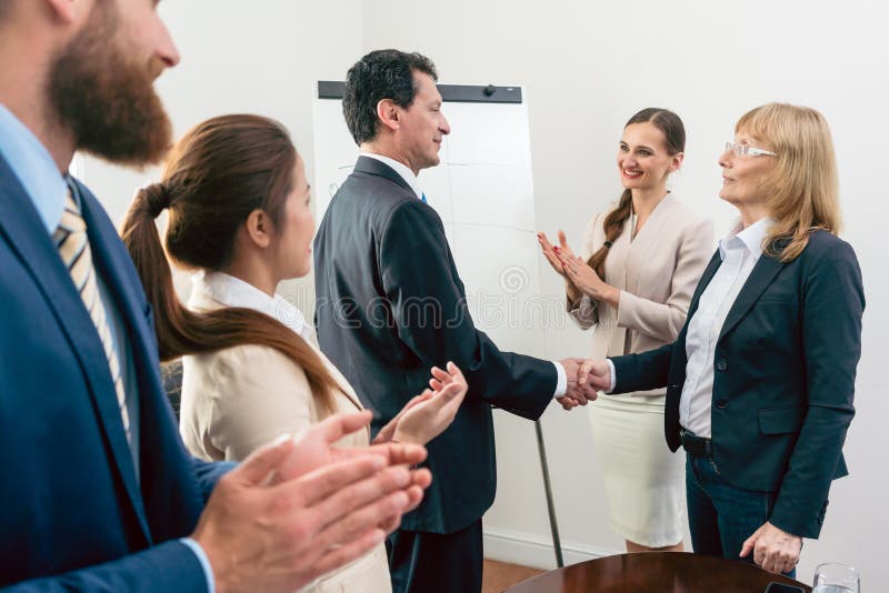 Due soci di mezza età di affari che sorridono mentre stringendo le mani fotografia stock Due soci di mezza età di affari che sorridono mentre stringendo le mani fotografia stock