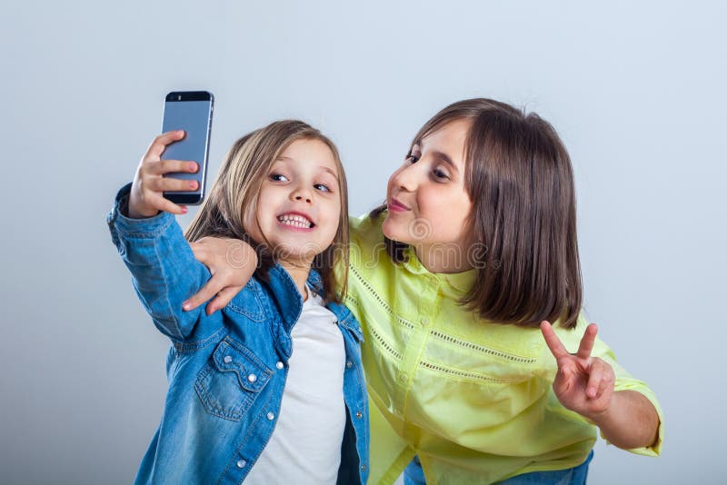 Due sorelle che posano e che prendono i selfies nello studio fotografia stock libera da diritti