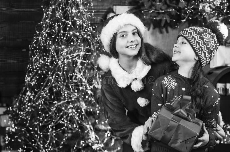 Due sorelle scambiano regali con xmas. bambine di santa in una stanza decorata. festa della famiglia. amicizia fotografie stock