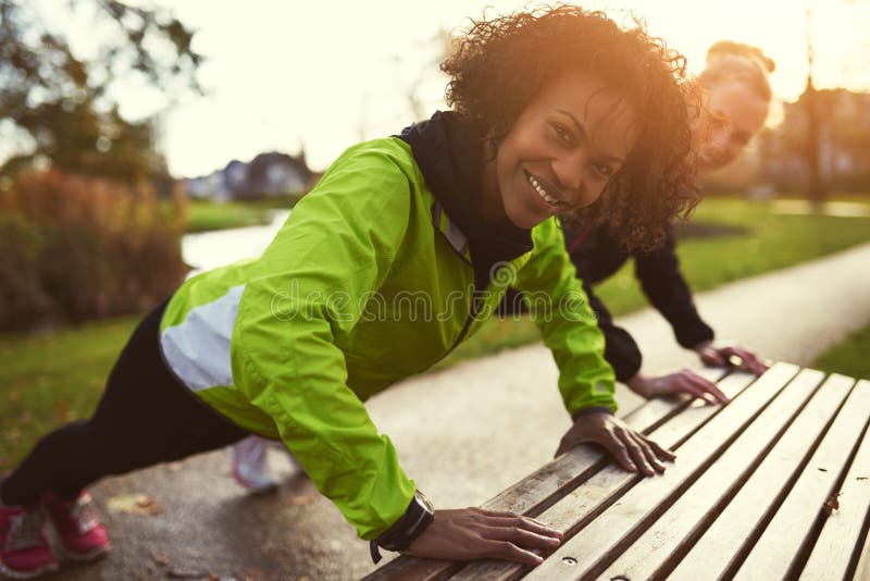 Due sportive sorridenti che fanno spinta-UPS fotografia stock libera da diritti Due sportive sorridenti che fanno spinta-UPS fotografia stock libera da diritti