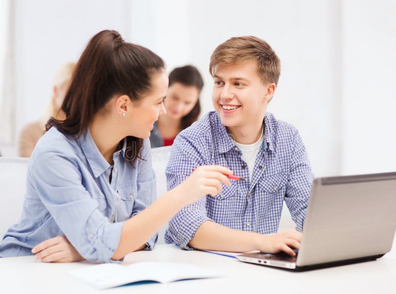 Due studenti sorridenti con il computer portatile immagini stock Due studenti sorridenti con il computer portatile immagini stock