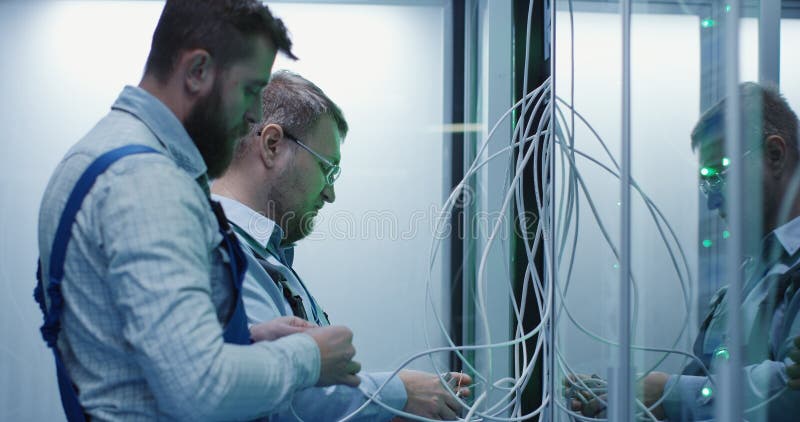 Due tecnici maschii che lavorano in un centro dati fotografia stock libera da diritti