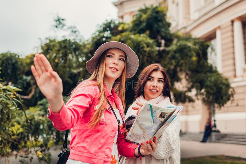 Due turisti delle donne che cercano il giusto modo facendo uso della mappa a Odessa dal teatro dell'opera Indicare felice dei via fotografia stock Due turisti delle donne che cercano il giusto modo facendo uso della mappa a Odessa dal teatro dell'opera Indicare felice dei via fotografia stock