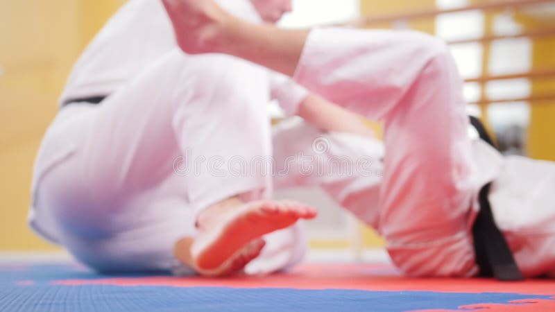 Due uomini atletici che preparano le loro abilità di aikidi nello studio Lancio dell'oppositore sul pavimento