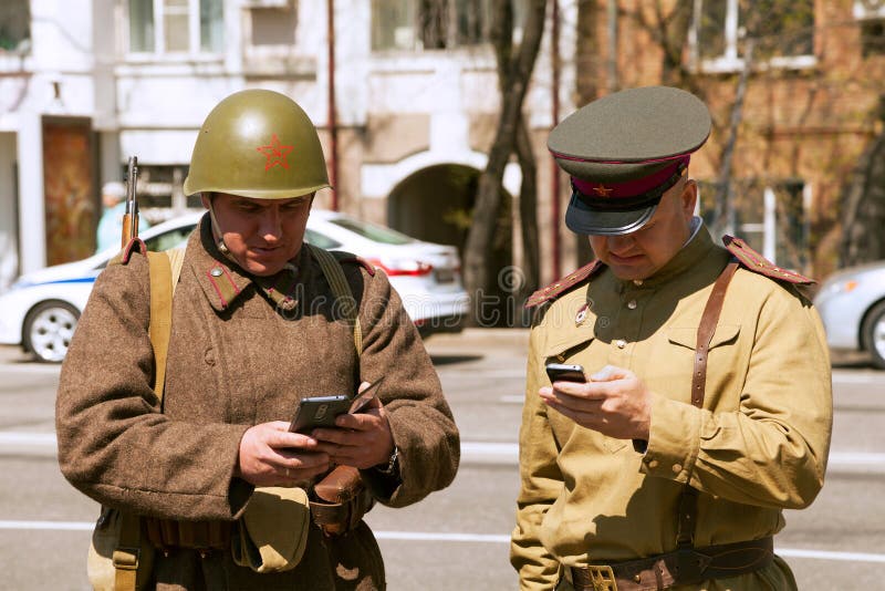 Khabarovsk, Russia - May 9, 2017: Funny incongruous USSR soldiers holding cellphones. Khabarovsk, Russia - May 9, 2017: Funny incongruous USSR soldiers holding cellphones