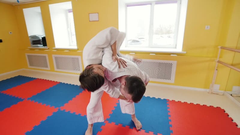 Due uomini che preparano le loro abilit? di aikidi Un uomo afferra il suo oppositore e lo getta pi? sul pavimento