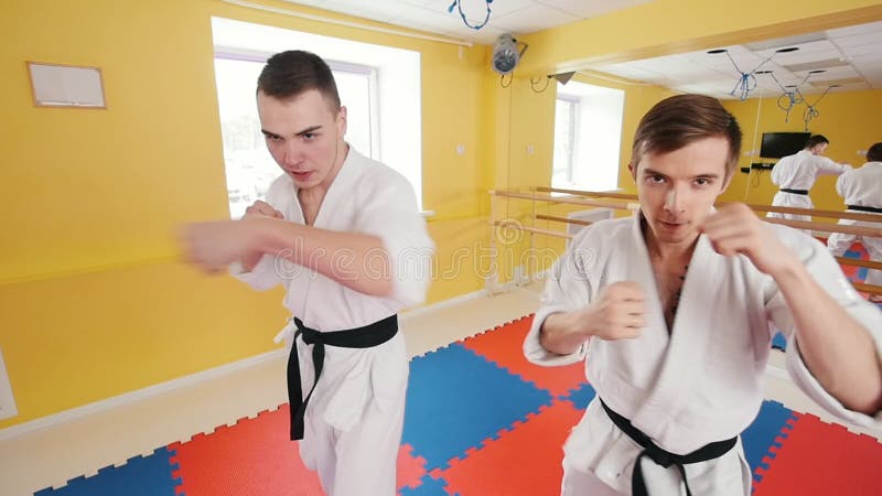 Due uomini che preparano le loro abilità di aikidi nello studio luminoso Formazione dei loro fistfights