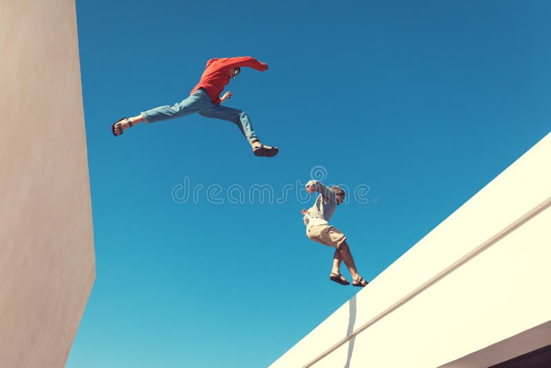Due uomini coraggiosi che saltano sopra il tetto