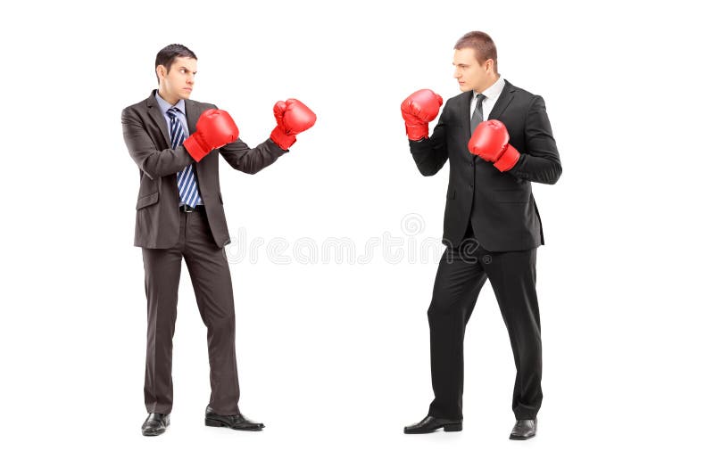 Due uomini d'affari litigando con i guantoni da pugile fotografia stock Due uomini d'affari litigando con i guantoni da pugile fotografia stock