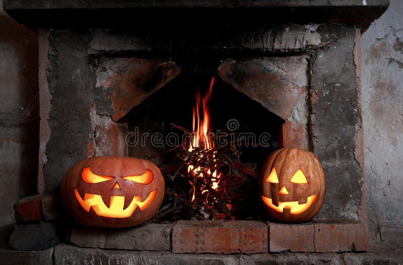 Due zucche di Halloween al camino con fuoco immagini stock