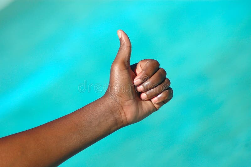 A black hand of an optimistic African American woman with thumb up to show a positive successful future. A black hand of an optimistic African American woman with thumb up to show a positive successful future