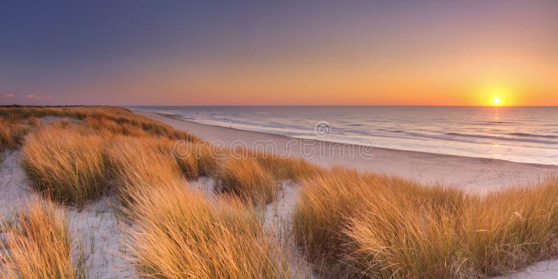 Duinen en strand bij zonsondergang op Texel-eiland, Nederland