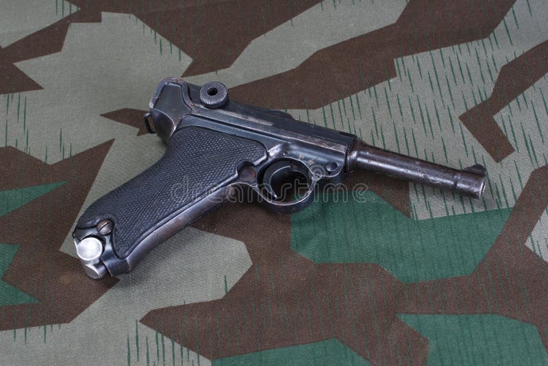 Duits het legerpistool van de Wereldoorlog IIperiode met het Duitse Kruis 1914 van het toekenningsijzer op gecamoufleerd stock afbeeldingen Duits het legerpistool van de Wereldoorlog IIperiode met het Duitse Kruis 1914 van het toekenningsijzer op gecamoufleerd stock afbeeldingen