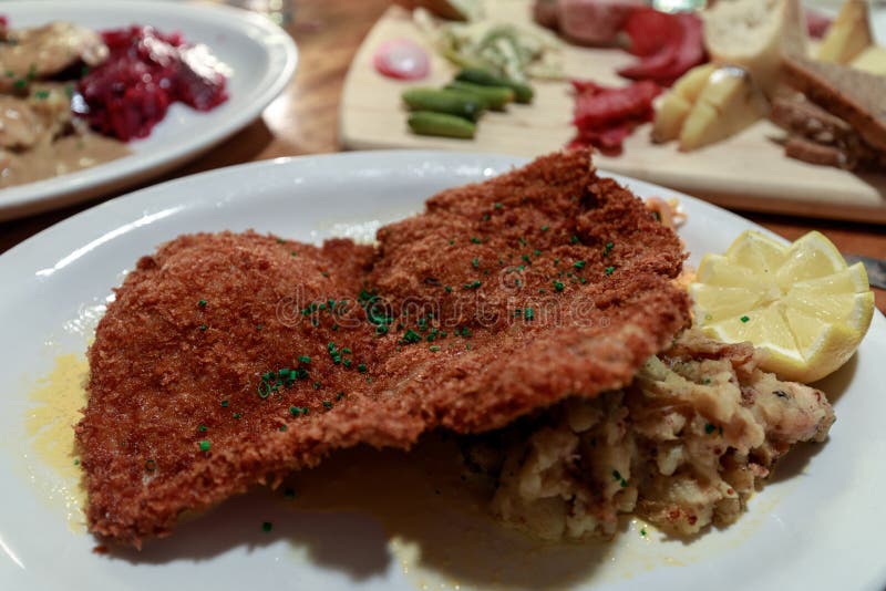 Duitse varkensvleesschnitzel en gebraden aardappels stock afbeeldingen Duitse varkensvleesschnitzel en gebraden aardappels stock afbeeldingen