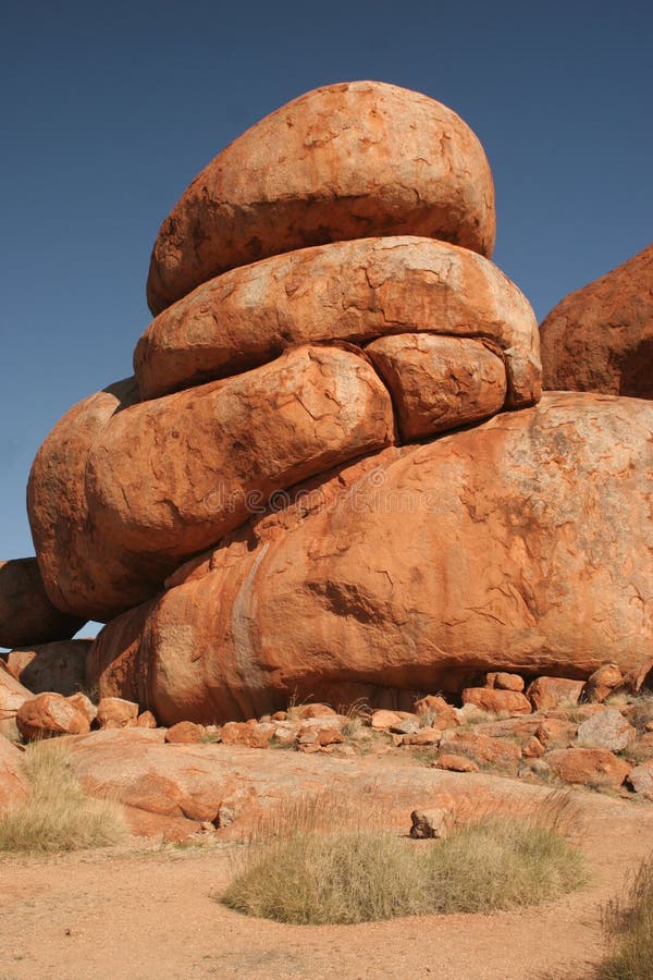 The Devils Marbles are a collection of huge, round, red-colored granite boulders, they are located in the Tennant Creek region of Australia's Northern Territory. The origin of the boulders may by explain by a geological way or by Aboriginal creation story of the Dreaming. The geological explanation is that the granite was formed millions years ago as a result of the hardening of magma within the Earth's crust. Thick layers of sandstone on top of it put a lot of pressure on this granite. Folding of the Earth's crust lead to the lifting of the granite and the erosion of the sandstone, the granite came to the surface. The second phase of the formation of the Marbles started when the blocks were exposed to water erosion and a layer of loose material surrounded the individual blocks. The rounding of the granite blocks is a result of both chemical as well as mechanical weathering. There are number of creation story of the Dreaming, explaining the origin of the Devil Marbles (called Karlu Karlu by Aboriginal traditional owners), but most of them are not to be told to uninitiated people. Karklu Karlu is a place of great spiritual significance and sacred site to traditional owners. The Devils Marbles are a collection of huge, round, red-colored granite boulders, they are located in the Tennant Creek region of Australia's Northern Territory. The origin of the boulders may by explain by a geological way or by Aboriginal creation story of the Dreaming. The geological explanation is that the granite was formed millions years ago as a result of the hardening of magma within the Earth's crust. Thick layers of sandstone on top of it put a lot of pressure on this granite. Folding of the Earth's crust lead to the lifting of the granite and the erosion of the sandstone, the granite came to the surface. The second phase of the formation of the Marbles started when the blocks were exposed to water erosion and a layer of loose material surrounded the individual blocks. The rounding of the granite blocks is a result of both chemical as well as mechanical weathering. There are number of creation story of the Dreaming, explaining the origin of the Devil Marbles (called Karlu Karlu by Aboriginal traditional owners), but most of them are not to be told to uninitiated people. Karklu Karlu is a place of great spiritual significance and sacred site to traditional owners.