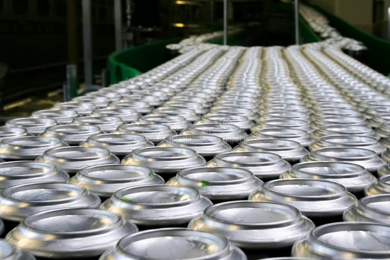 Thousands of beverage aluminum cans on conveyor line at factory. Concept of industrial power and growth. Thousands of beverage aluminum cans on conveyor line at factory. Concept of industrial power and growth