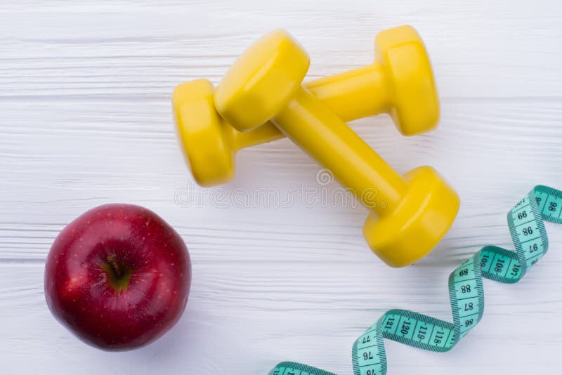 Dumbbells, red apple and measuring tape. royalty free stock image Dumbbells, red apple and measuring tape. royalty free stock image