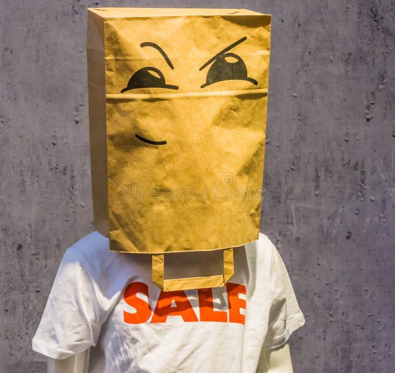 Dummy wearing a funny paper bag over its head with a angry face on it, T-sh...