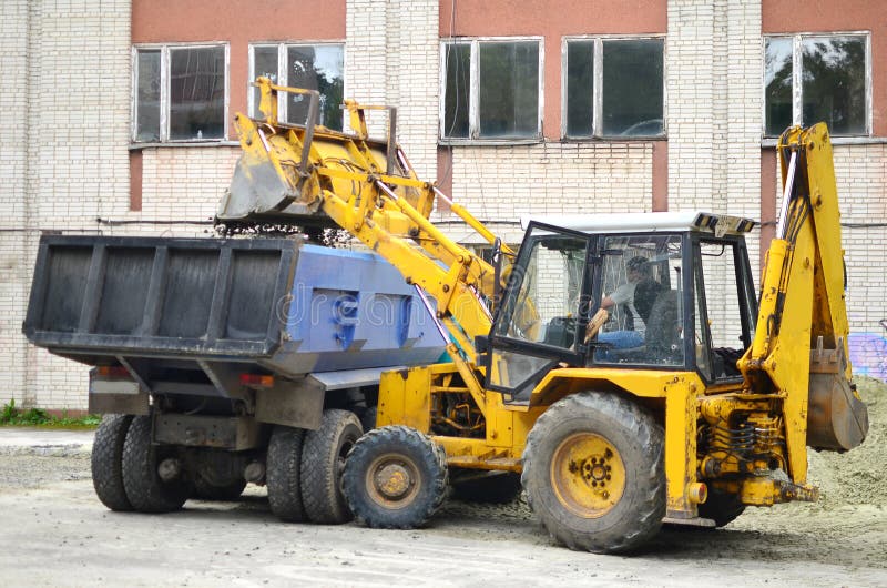 Dumper truck unloading soil or sand at construction site during road works at blue sky background. Dumper truck unloading soil or sand at construction site during road works at blue sky background