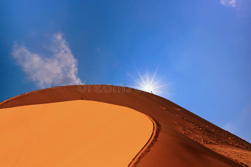 Duna de arena grande en Namibia con el sol que mira furtivamente sobre el borde imagen de archivo libre de regalías Duna de arena grande en Namibia con el sol que mira furtivamente sobre el borde imagen de archivo libre de regalías