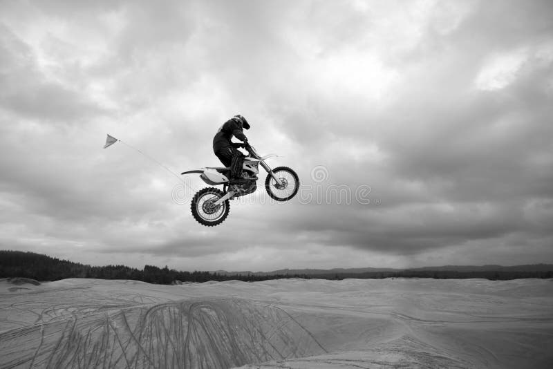 Dunas de arena de salto de la bici de la suciedad - arriba para arriba fotografía de archivo Dunas de arena de salto de la bici de la suciedad - arriba para arriba fotografía de archivo