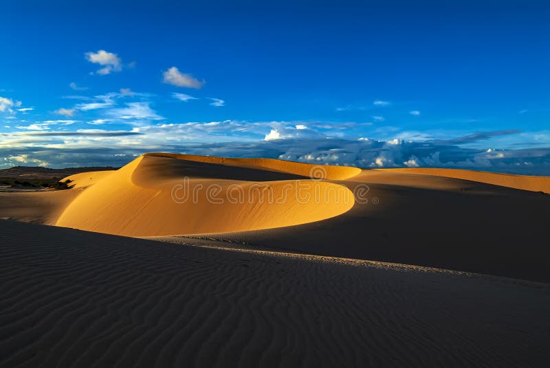 Dunas de arena en la puesta del sol con el cielo azul fotos de archivo libres de regalías Dunas de arena en la puesta del sol con el cielo azul fotos de archivo libres de regalías