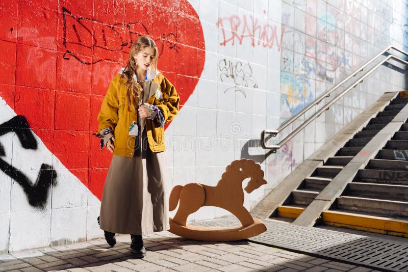 Dunkelhaarige moderne Frau, die langen Rock und gelbe Jacke trägt lizenzfreie stockfotos Dunkelhaarige moderne Frau, die langen Rock und gelbe Jacke trägt lizenzfreie stockfotos