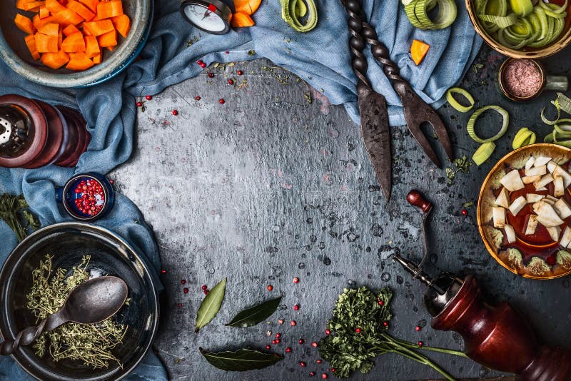 Dunkler rustikaler vegetarischer Lebensmittelhintergrund mit Schüsseln gehacktem Gemüse und Gewürzbestandteilen und Küchenwerkzeu stockfotografie