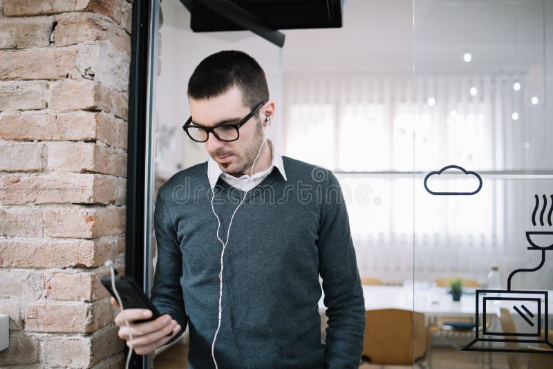 Dunne Man Met Hoofdtelefoon En Bril Op Een Telefoon Stock Afbeelding - of mannetje, freelance: 173358407