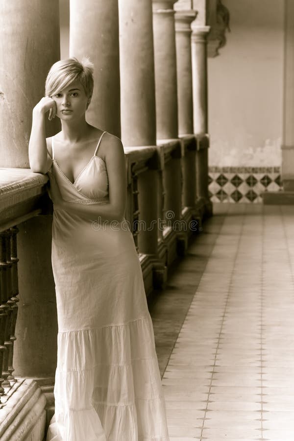 Thoughtful woman in classic interior building, sepia toned. Thoughtful woman in classic interior building, sepia toned.