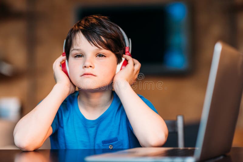 Durchdachte hörende Musik des kleinen Jungen in den Kopfhörern stockfoto Durchdachte hörende Musik des kleinen Jungen in den Kopfhörern stockfoto