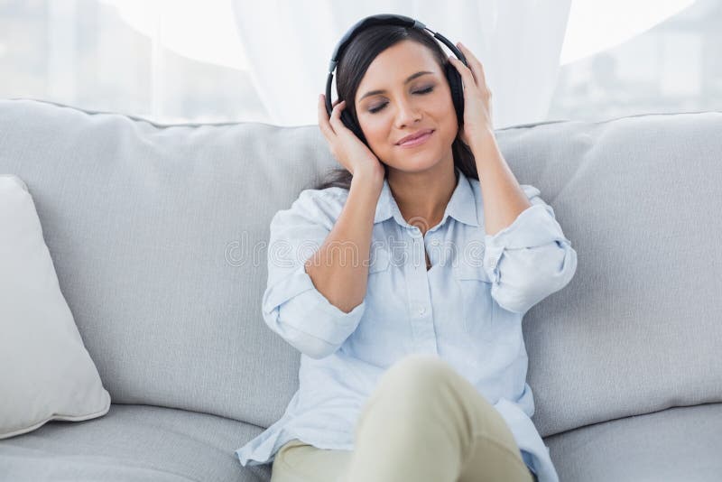 Durchdachter Brunette, der Musik hört lizenzfreie stockfotografie Durchdachter Brunette, der Musik hört lizenzfreie stockfotografie
