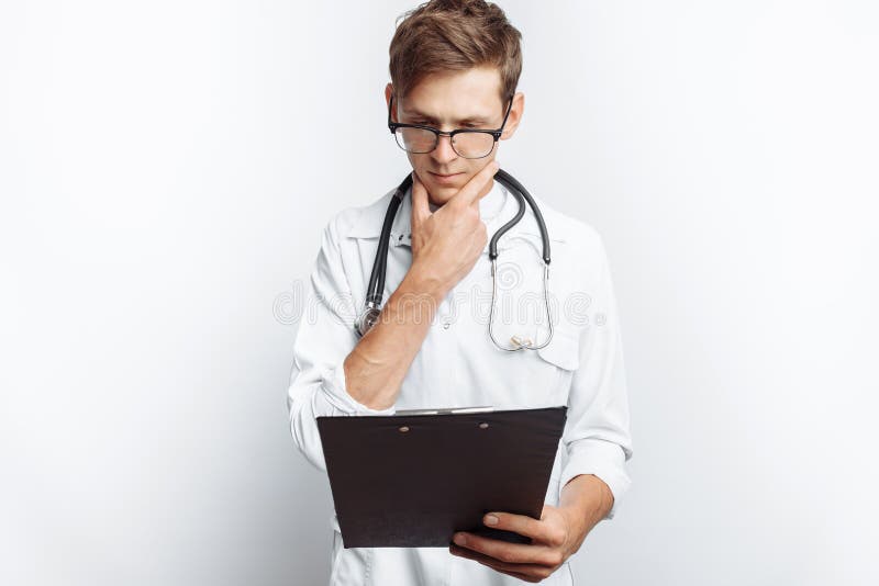 Durchdachter Doktor, die Dokumente betrachtend und macht Anmerkungen in den Dokumenten, ein junger Student mit einem Ordner in se lizenzfreie stockfotografie Durchdachter Doktor, die Dokumente betrachtend und macht Anmerkungen in den Dokumenten, ein junger Student mit einem Ordner in se lizenzfreie stockfotografie